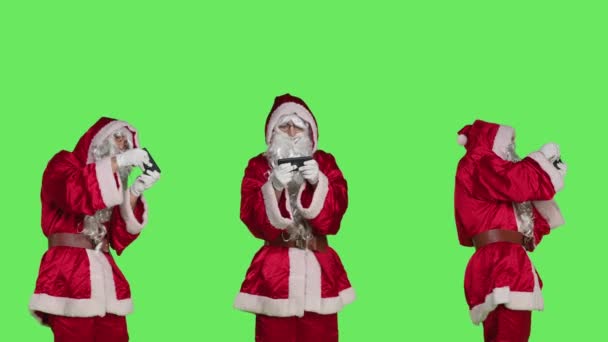 Santa Claus在电话上玩电子游戏 在网上玩手机游戏游戏 在绿屏 娱乐节目和休闲节目中扮演身穿红色服装的圣诞老人 — 图库视频影像