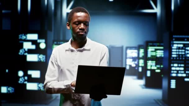 Afrykański Amerykański Mechanik Używający Laptopa Przeglądania Zużycia Energii Szafach Serwerowych — Wideo stockowe