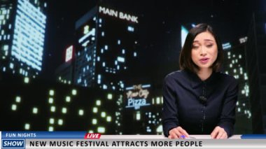 Haber spikeri, kentteki müzik festivalinin kapılarını açtığını duyurdu ve konserlerdeki yeni eğlenceli etkinlikler hakkında bilgi sundu. Kadın yayıncı haber stüdyosunda gece yarısı televizyon programı sunuyor..
