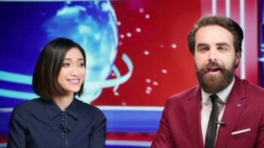 Çeşitli sunucular haber stüdyosunda sunuculuk yapıyor ve uluslararası televizyon programında günlük önemli olayları tartışıyorlar. Eğlence bölümünde çalışan gazeteci, canlı yayında manşetleri okuyor.