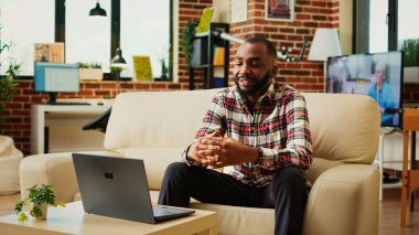 Konforlu dairede çalışan bir yönetici, video konferans sırasında iş arkadaşlarıyla tartışıyor. Neşeli yönetici uzaktan çalışan meslektaşları ve el kamerasıyla çevrimiçi video görüşmesi yapıyor.