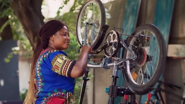 Αφροαμερικανή Γυναίκα Που Ελέγχει Προσεκτικά Εξαρτήματα Ποδηλάτων Εξασφαλίζοντας Ομαλή Και — Αρχείο Βίντεο