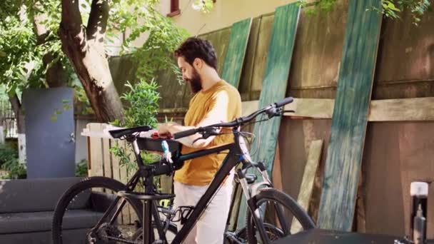 自転車のツールボックスを自宅の庭に運ぶ警官の肖像写真 外でアクティブな男性のサイクリスト プロのツールキットを把握し 自転車を修理する作業ツールを探しています ドリー ズームイン — ストック動画