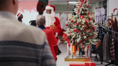 Noel Baba kıyafeti giyen çalışanlar Noel süslü alışveriş merkezi giyim mağazasında çekiliş yarışması düzenliyor. Kış tatilinde yaşlı çiftleri katılmaya davet ediyor.