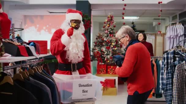 Employee Wearing Santa Claus Costume Collecting Unneeded Clothes Generous Shoppers — Stock Video