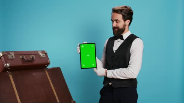 Elegancki Boy Hotelowy Trzymający Tablet Przed Kamerą Prezentujący Pusty Zielony — Wideo stockowe
