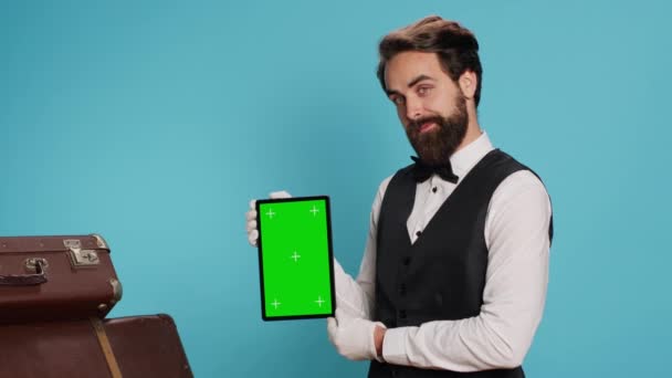 Deurwachter Houdt Tablet Met Geïsoleerde Display Poseren Tegen Een Blauwe — Stockvideo