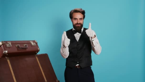Готельний Консьєрж Показує Великі Пальці Студії Діючи Позитивно Оптимістично Синьому — стокове відео