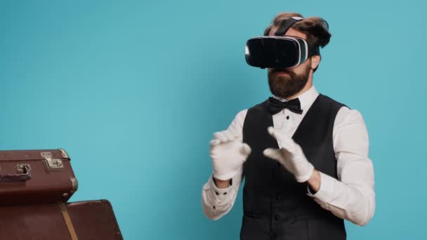Nowoczesny Boy Hotelowy Przymierzający Okulary Niebieskim Tle Wykorzystujący Technologię Wirtualnej — Wideo stockowe