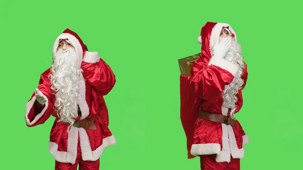 可爱的桑塔 克劳斯在绿屏演播室里 以轻柔的动作 给人一种甜蜜的空气之吻 浪漫的男人在镜头前扮演圣人尼克的角色 在圣诞节前夕提着礼物提包 — 图库照片