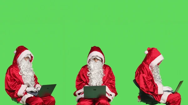 Moderní Santa Claus Pracuje Notebooku Zelené Pozadí Studiu Otec Vánoce — Stock fotografie