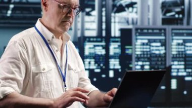Endüstriyel sunucu odasında gezinirken verileri ustalıkla yöneten lisanslı bir servis elemanı. Teknik destek yürütme optimum siber güvenlik koruması sağlama, sistemleri optimize etme