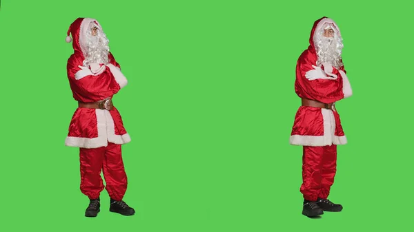 身穿桑塔服装的男人感到不耐烦 一边站在全身上下绿屏的背景上 一边等待着什么 圣尼克的角色在工作室里走来走去 圣诞节前夕 — 图库照片