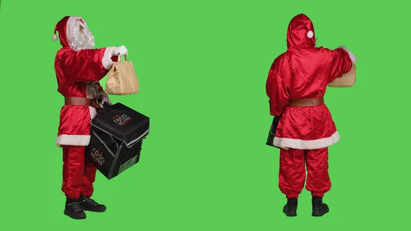 圣诞老人是用纸袋送货上门的 在节日庆祝活动中 穿得像圣诞老人 留着白胡子的人送来速食订单 带有热背包的人物 全身绿屏 — 图库照片