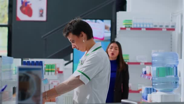アジアのクライアントは 化学工場のデジタルスクリーンで医薬品の広告を見て 広告された薬を購入する意図で薬剤師に近づいています 専門家は情報の買い物客を助けます — ストック動画