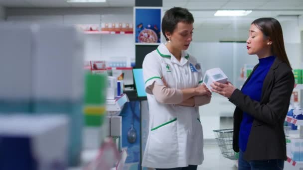 开有执照的药房药剂师 为购物者提供芦荟产品 治疗晒伤 药房的医护人员帮助亚洲妇女止痛镇痛膏 — 图库视频影像