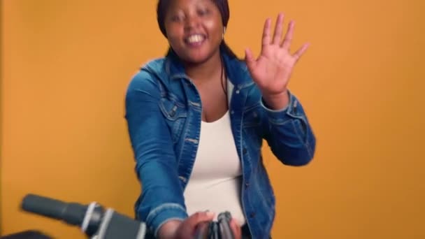 骑自行车的女信使手持手机自拍的Pov视频在网上聊天 用Vlog进行远程交谈 黑人女人聊着快递员的工作 — 图库视频影像