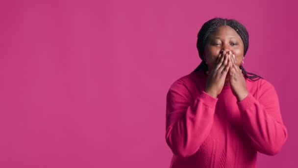 非洲裔美国女士向相机送吻 而优雅地站在孤立的粉红色背景 聪明快乐的黑人女人用可爱的手势传达爱意 散发爱意 — 图库视频影像