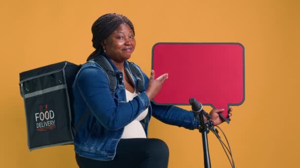 Afroamerikanische Zustellerin Mit Rucksack Der Auf Rotem Schild Der Hand — Stockvideo