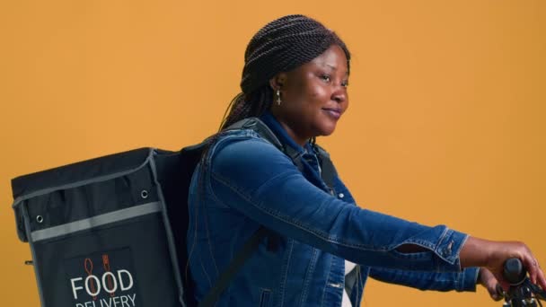 可靠的非洲裔美国人送货人背着袋子 把食物送到市区附近 积极的黑人妇女使用自行车作为环保交通工具 提供可靠的信使服务 — 图库视频影像