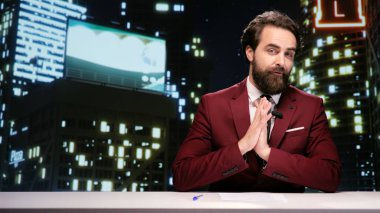 Gece TV sunucusu canlı yayında son zamanlardaki ünlülerle ilgili haberleri sunuyor. Medya sunucusu önemli küresel konulara son dakika haberleriyle değiniyor, talk show sunuyor.