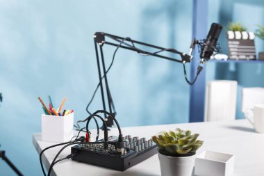 Ses kontrol konsolu ve profesyonel mikrofon boş blog çalışma alanındaki masada. Ses karıştırıcı profesyonel ekipman Vlogger ev stüdyosunda masasında hiç insan olmadan