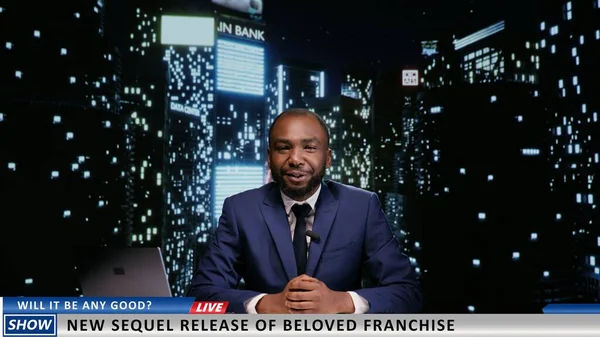 Presenter announcing new movie premiere on late night talk show, discussing about famous film franchise on live television program. African american host presenting world news.