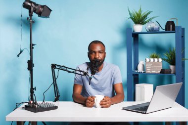 Blogger kameraya bakarken video kanalı için canlı yayın ve canlı yayın yapıyor. Afrikalı Amerikalı vlogger dijital içerik yaratıyor ve kamerada konuşuyor