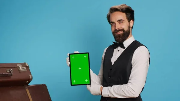 Stylowy Boy Hotelowy Prezentuje Tablet Studio Pokazuje Pusty Zielony Ekran — Zdjęcie stockowe