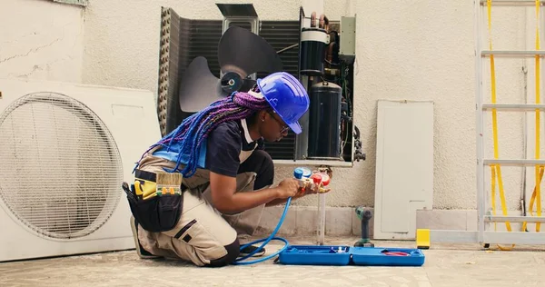 Knowleadgeable engineer preparing for annual condenser maintenance. Efficient technician unpacking toolset box with professional gear needed to mend damaged air conditioner internal parts