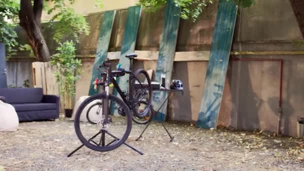 現代的な自転車は夏の活動として庭の専門装置との徹底的な検査そして修理を待っています 修理プラットフォームに配置された損傷した自転車は 微調整と調整のために — ストック動画