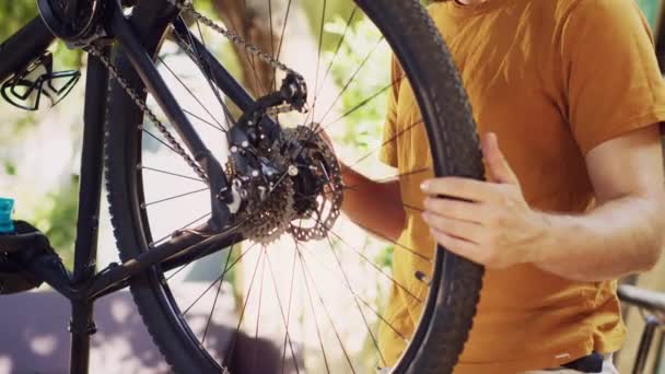 エネルギッシュなフィットは 特定のツールを使用して自転車のコンポーネントを修理し 維持する外側の慎重な男 男性のサイクリストは 大きな熱意を持って損傷した自転車を慎重に調べ 修理します — ストック動画