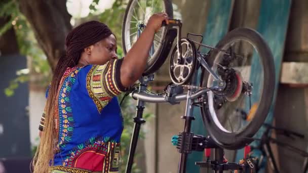 Tutkulu Afrikalı Amerikalı Bayan Bisiklet Pedallarını Zincirlerini Özenle Inceliyor Ayarlıyor — Stok video