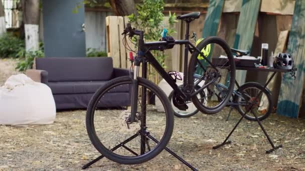 被损坏的自行车在家里的院子里等待修理和维护 准备夏季骑自行车 安装在修理台上的现代自行车的景观 供户外进一步调整 — 图库视频影像