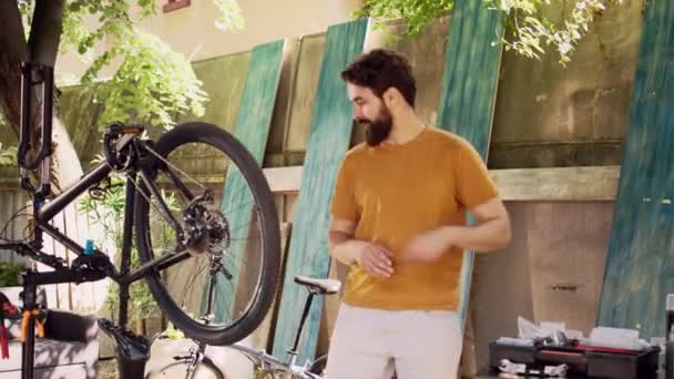爱好运动的男性骑自行车者在自家院子里用专业工具箱修理破自行车轮胎 白种人在自行车轮子上做着平常的夏季日常保养工作 既专业又准确 — 图库视频影像