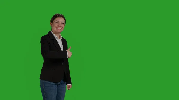 正面女性在绿屏背景下竖起大拇指 在工作室里表现得像个不错的标志 公司女员工在诉讼中做出认可和同意的姿态 — 图库照片