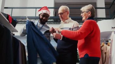 Noel tatili tanıtım sezonu tanıtım satışları sırasında ideal kıyafet bulan arkadaş canlısı perakende satış asistanı, alışveriş merkezi butiğindeki yaşlı çifte yardım ediyor.