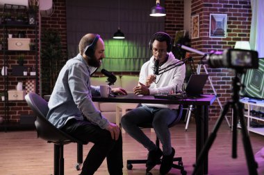 Canlı yayın tartışması ile internet içeriği yaratarak, podcast bölümünü birlikte yayınlamak üzere sunucu ve misafir toplantısını gösterin. Muhabbeti kaydetmek için profesyonel ekipman kullanan bir hukukçu mülakatı.