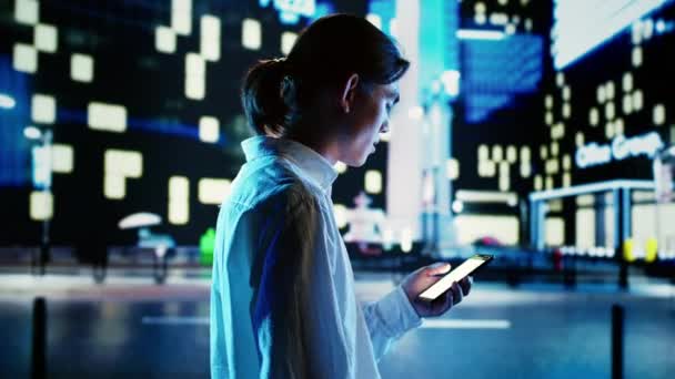 Азіатський Чоловік Ходить Міському Пейзажу Вночі Переглядаючи Інтернет Допомогою Смартфона — стокове відео