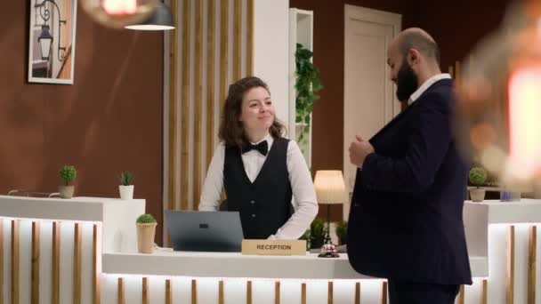 Der Concierge Des Hotels Überprüft Den Ausweis Des Gastes Und — Stockvideo