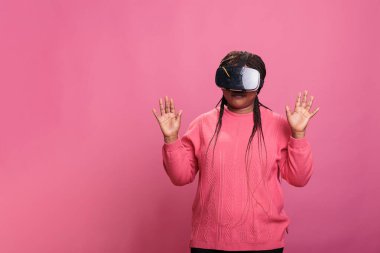 Gerçekçi video oyunları oynayan, sanal gerçeklik gözlüğü takan, dijital deneyimi olan, siber uzayı keşfeden neşeli gülümseyen bir kadın. Eğlence için vr gözlük kullanan neşeli bir model