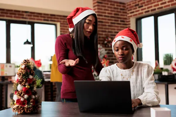 Asyalı Afrikalı Amerikalı Kadınlar Noel Süslemeli Ofiste Dizüstü Bilgisayarda Birlikte — Stok fotoğraf