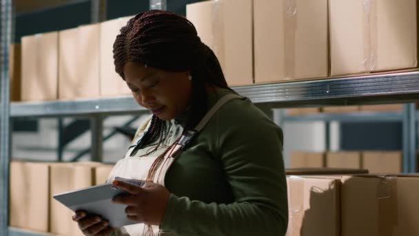 非洲裔美国仓库主管的肖像 曾用于平板电脑以监督包裹的运送 并随时跟踪仓库中的货物 准备发送给客户 — 图库视频影像