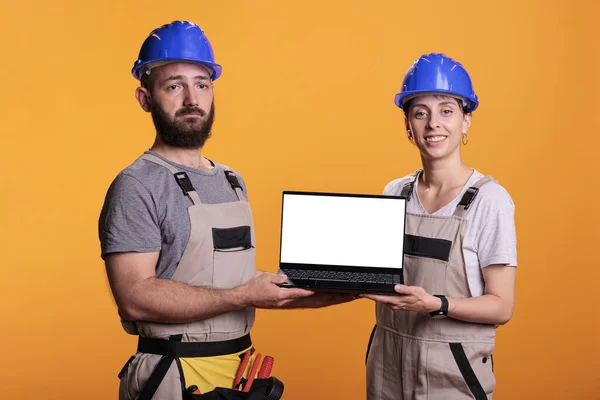 Equipe Construtores Mostrando Tela Branca Vazia Laptop Vestindo Macacões Hardhats — Fotografia de Stock