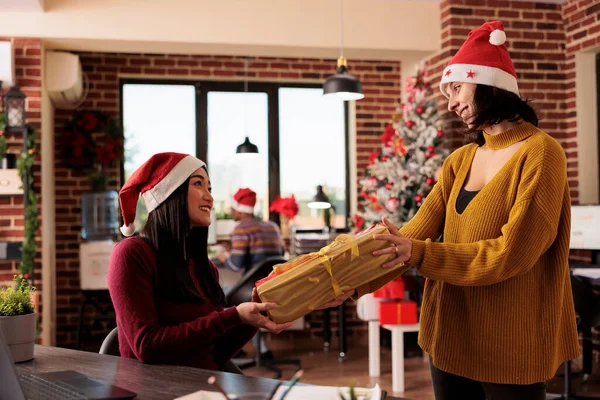 Dos Colegas Diversas Mujeres Que Comparten Regalo Navidad Mientras Trabajan —  Fotos de Stock