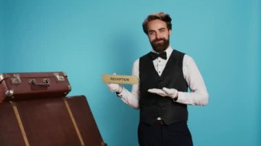 Otel çalışanları kamerada sinyal gösteriyor. Konuklar doğru yönde ya da doğru yerde. Turizm sektöründe çalışan profesyonel lüks kapıcı, resepsiyon göstergesi gösteriyor..