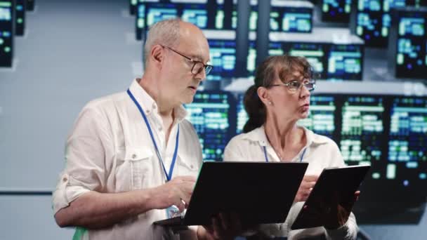 Fokuserade Inspektörer Tittar Runt Datacenter Med Hjälp Bärbar Dator Och — Stockvideo