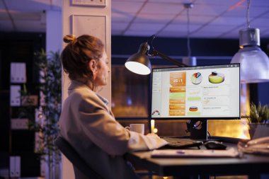 İş kadını, mali grafik raporunu analiz ediyor, kârı arttırmak için pazarlama stratejisinde fazla mesai yapıyor. Yönetici, başlangıç ofisindeki masa başında oturuyor. Şirket kavramı