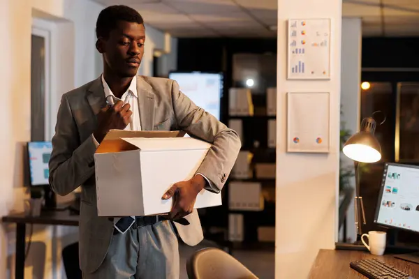 可悲的商人在深夜被公司经理解雇后离开了公司的初创办公室 失业企业家携带装有个人物品的纸板箱 — 图库照片