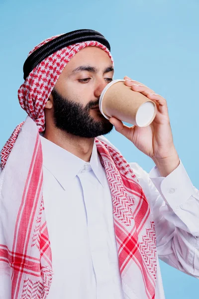 Geleneksel Müslüman Kıyafeti Giymiş Bir Adam Stüdyoda Kahvesini Yudumluyor Arap — Stok fotoğraf